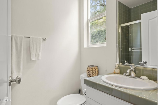 bathroom featuring an enclosed shower, vanity, and toilet