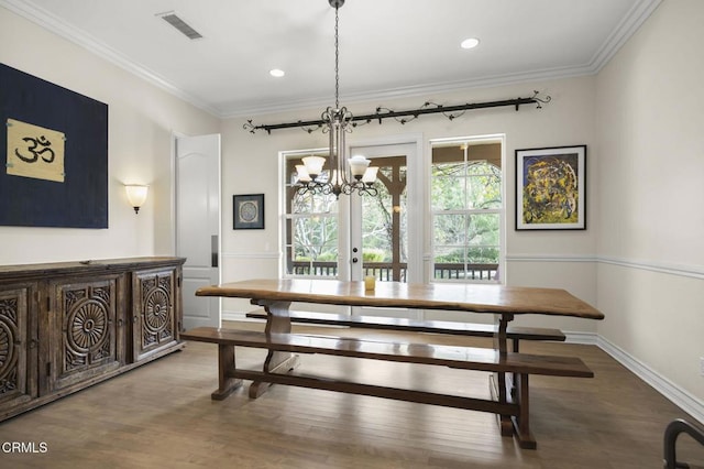 dining room with a notable chandelier, crown molding, wood-type flooring, and french doors