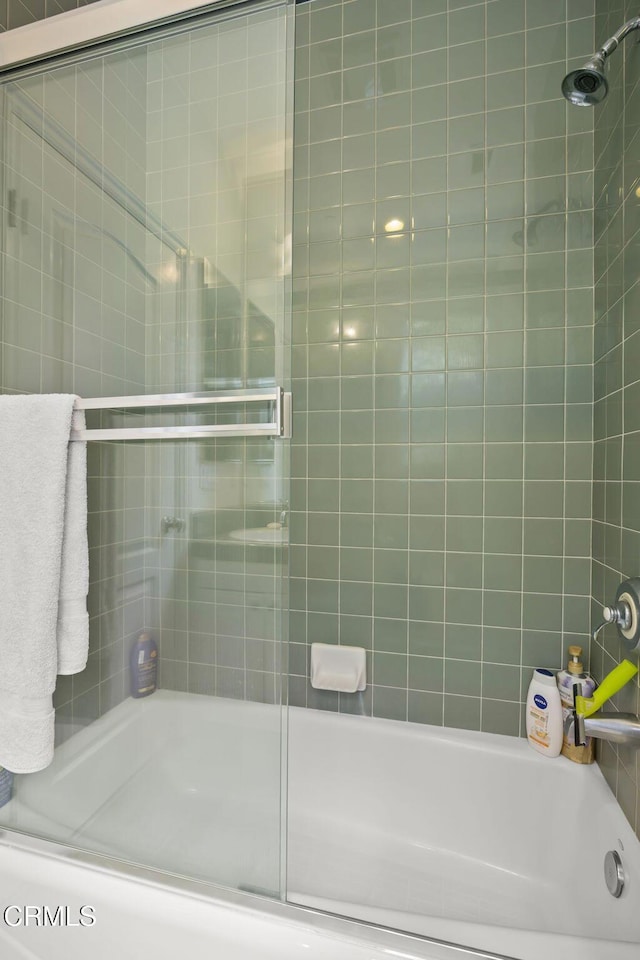 bathroom with bath / shower combo with glass door