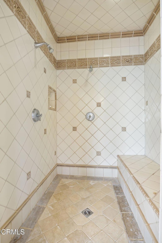 bathroom with a tile shower and tile patterned floors