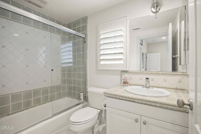 full bathroom with bath / shower combo with glass door, vanity, toilet, and backsplash