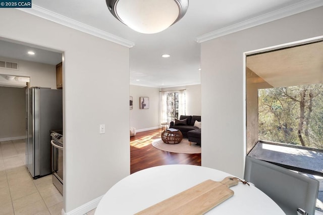 dining area with crown molding and light tile patterned flooring