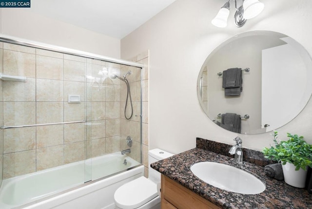 full bathroom featuring combined bath / shower with glass door, vanity, and toilet