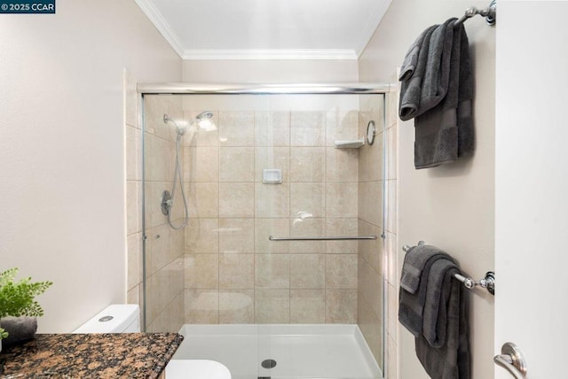 bathroom with toilet, a shower with shower door, and crown molding