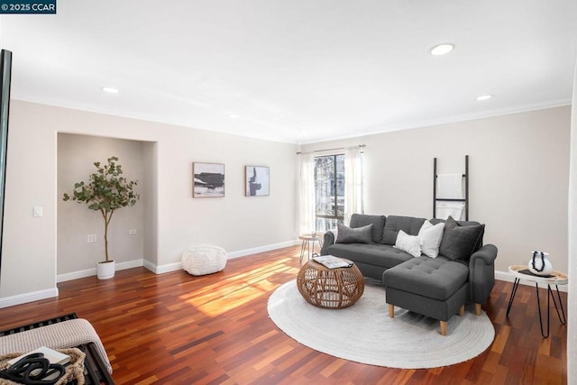 living room featuring wood-type flooring and crown molding