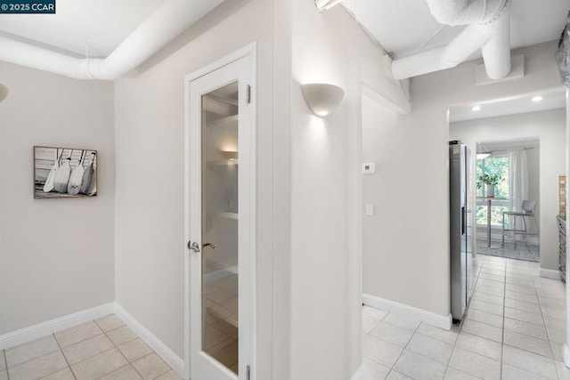 hall with light tile patterned floors