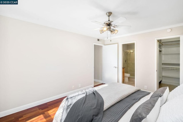 bedroom with a walk in closet, ceiling fan, connected bathroom, wood-type flooring, and a closet