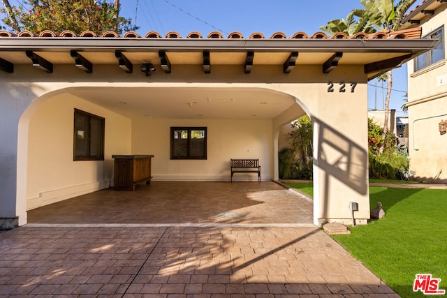 rear view of house featuring electric panel, a patio area, and a lawn