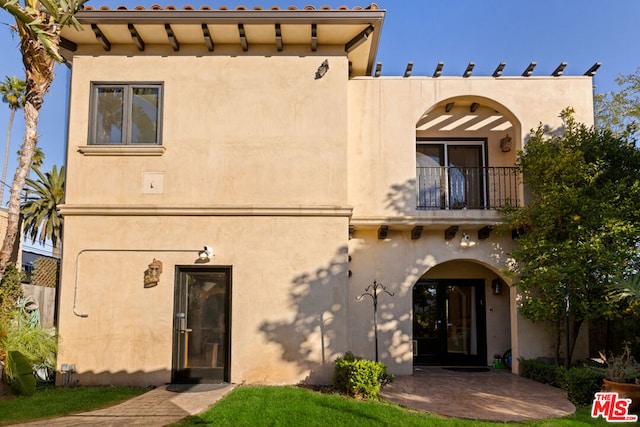 view of front of house with a patio and a balcony