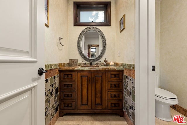 bathroom with tile patterned flooring, vanity, and toilet