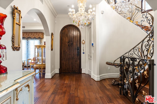 entryway featuring dark hardwood / wood-style floors, crown molding, and a chandelier