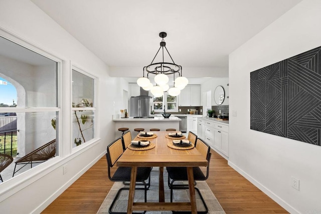 dining area featuring a chandelier, a wealth of natural light, and light hardwood / wood-style flooring