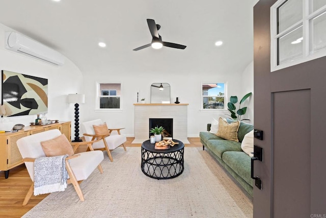 living room with hardwood / wood-style flooring, a wall mounted air conditioner, and ceiling fan