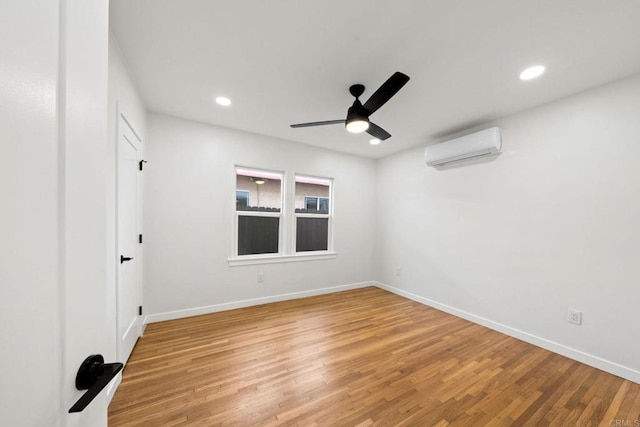 unfurnished room featuring an AC wall unit, wood-type flooring, and ceiling fan