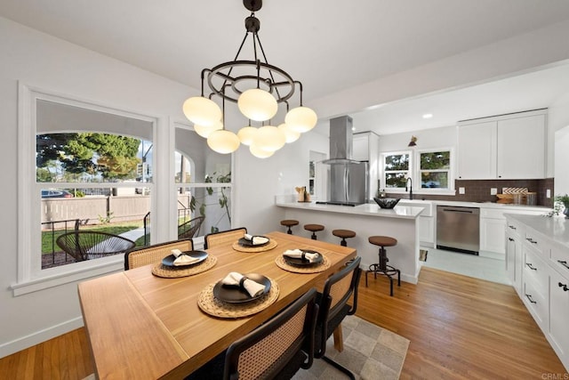 dining room featuring a notable chandelier, light hardwood / wood-style flooring, and sink