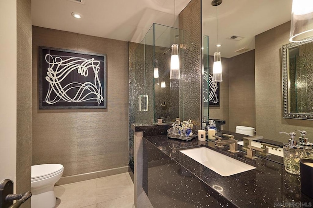 bathroom with toilet, vanity, tile patterned floors, and a shower with door