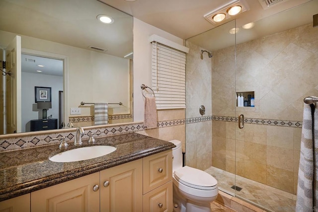 bathroom with toilet, vanity, tile walls, and walk in shower