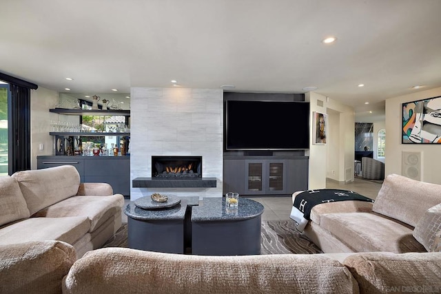 living room with a tile fireplace and tile patterned floors