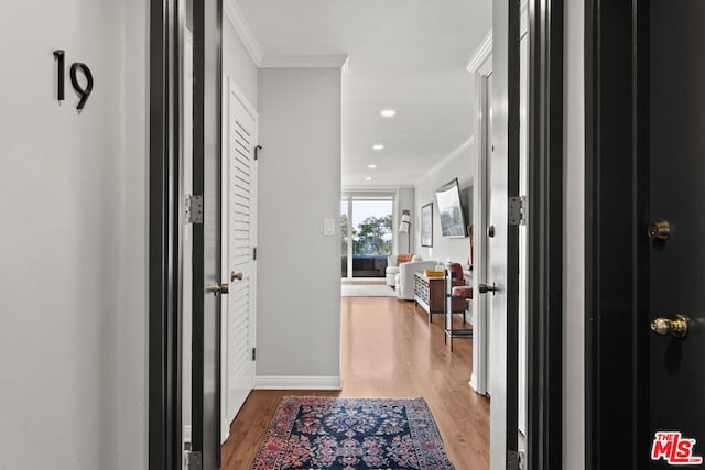 hall with ornamental molding and hardwood / wood-style floors