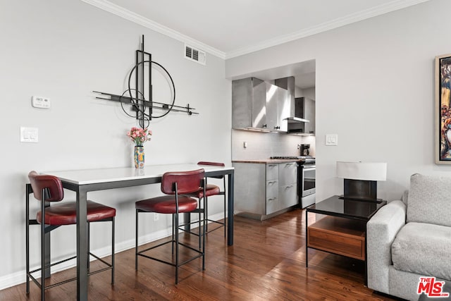 dining area featuring dark hardwood / wood-style flooring and crown molding