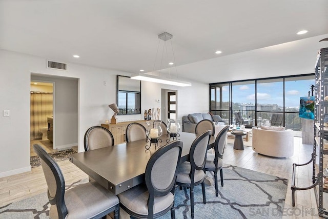 dining space with light wood-type flooring and floor to ceiling windows