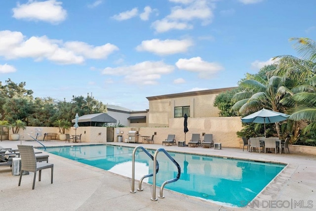 view of pool with a patio area and a grill