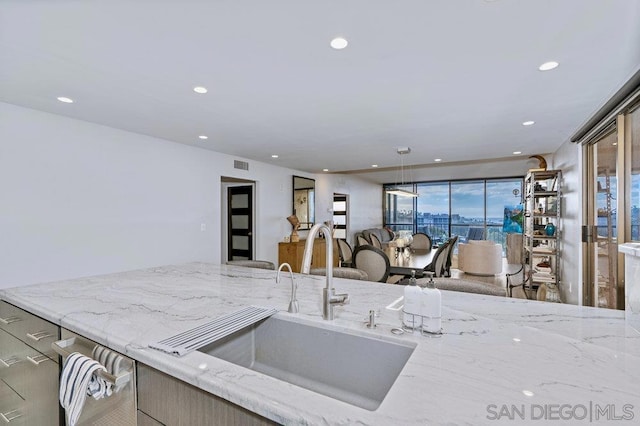 kitchen with light stone countertops and sink