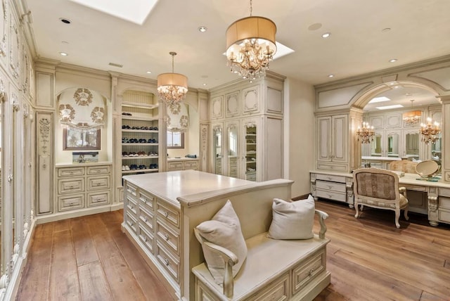 spacious closet featuring a chandelier and light wood-type flooring