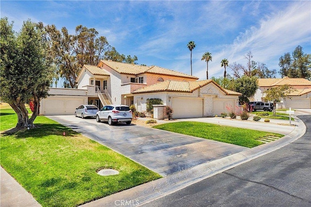 mediterranean / spanish-style house with a garage and a front lawn