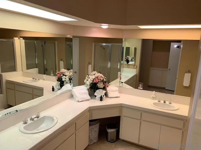 bathroom featuring vanity, a shower with shower door, and tile patterned floors