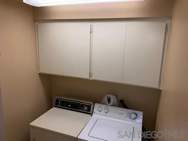 laundry area featuring cabinets and washing machine and clothes dryer