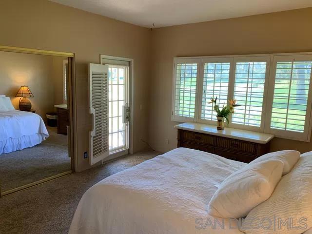 bedroom with carpet and access to outside