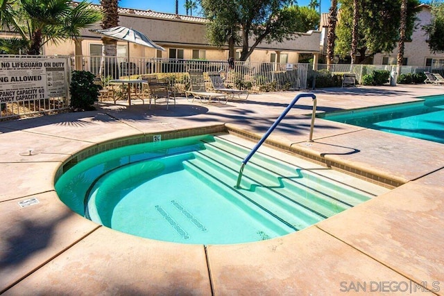 view of pool with a patio area and a community hot tub