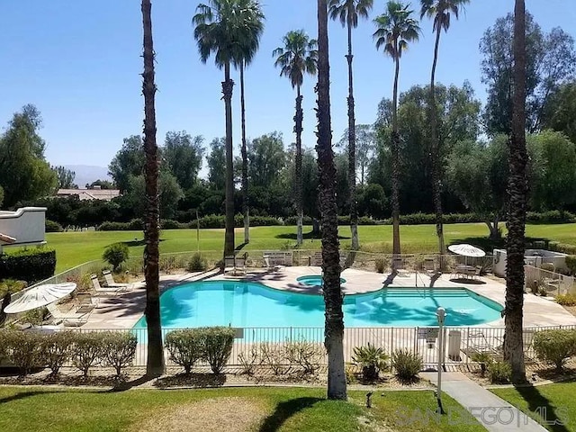 view of swimming pool featuring a lawn and a patio