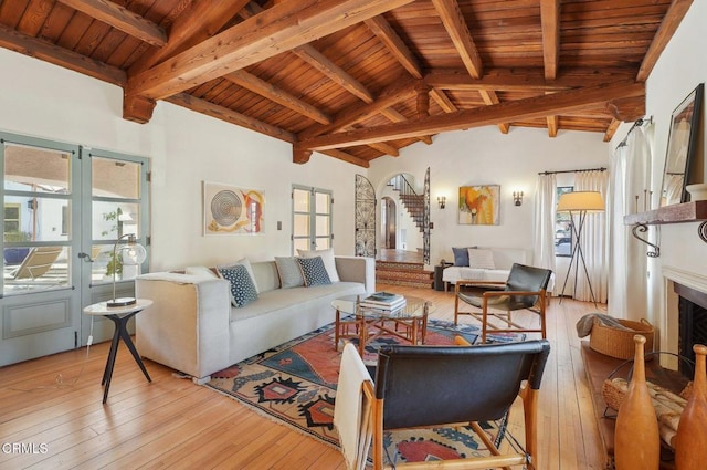 living room featuring high vaulted ceiling, beamed ceiling, wooden ceiling, and light wood-type flooring