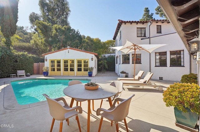 view of swimming pool featuring a patio area and an outbuilding