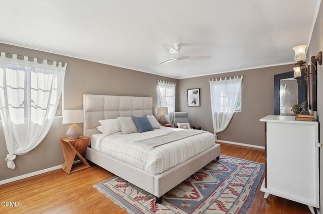 bedroom featuring hardwood / wood-style flooring, ceiling fan, and ornamental molding