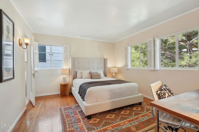 bedroom featuring light hardwood / wood-style floors and crown molding