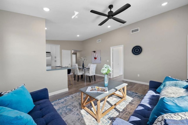 living room featuring ceiling fan and dark hardwood / wood-style floors