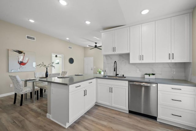 kitchen with kitchen peninsula, ceiling fan, sink, dishwasher, and white cabinetry