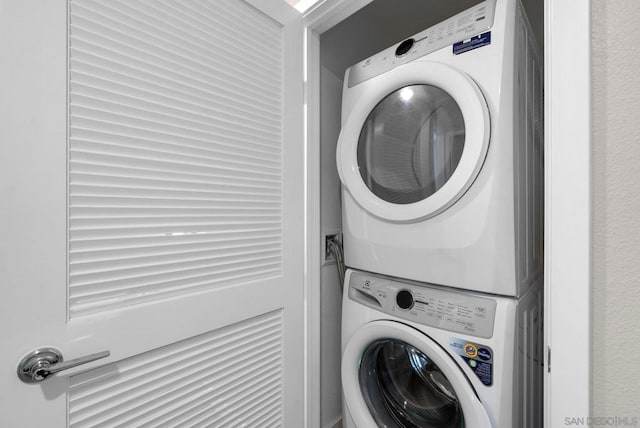 clothes washing area featuring stacked washer and dryer