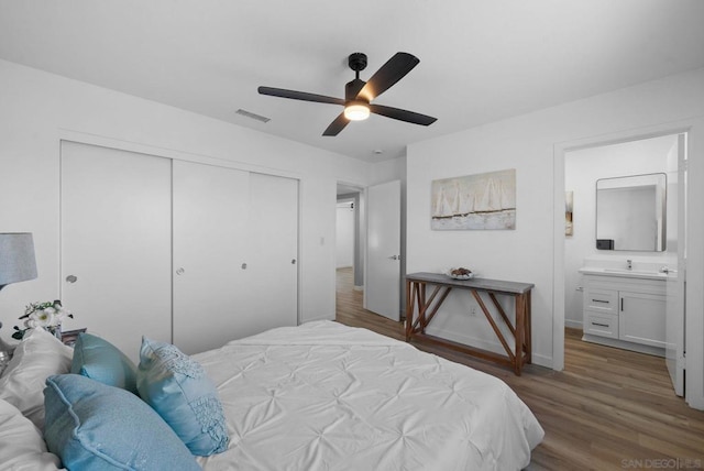 bedroom featuring ceiling fan, dark hardwood / wood-style flooring, connected bathroom, and a closet