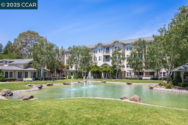 surrounding community featuring a lawn and a water view