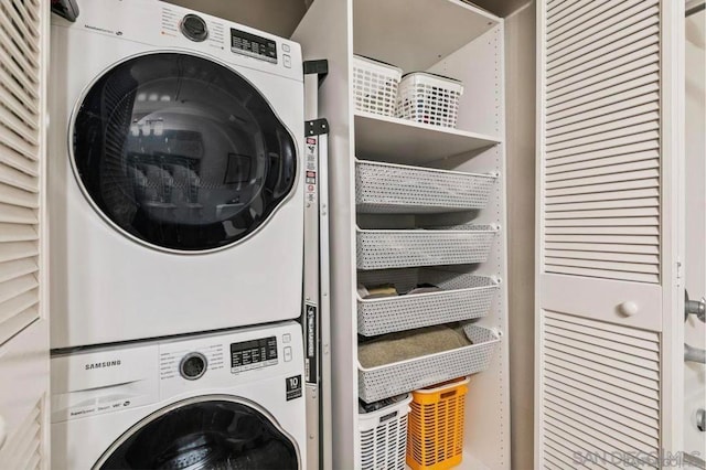 washroom featuring stacked washer and clothes dryer