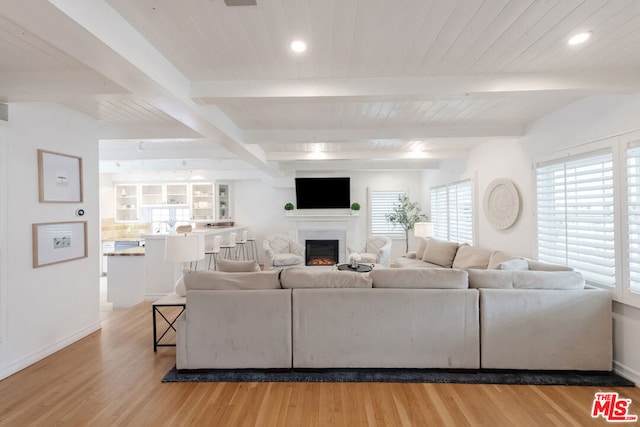 living room featuring hardwood / wood-style flooring, wooden ceiling, and beamed ceiling