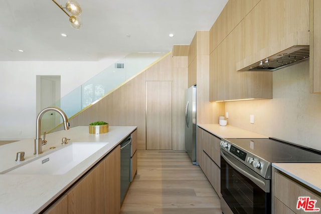 kitchen featuring light brown cabinetry, sink, appliances with stainless steel finishes, and light hardwood / wood-style flooring