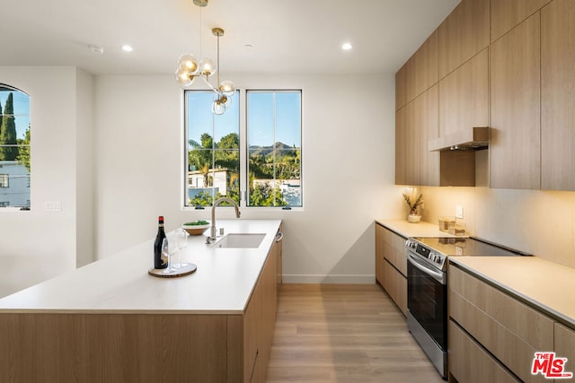 kitchen with light brown cabinets, stainless steel electric stove, hanging light fixtures, sink, and range hood