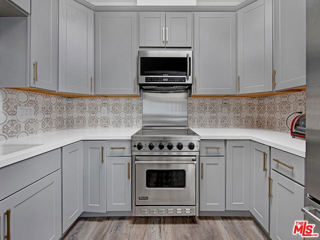 kitchen with backsplash, gray cabinets, and stainless steel appliances