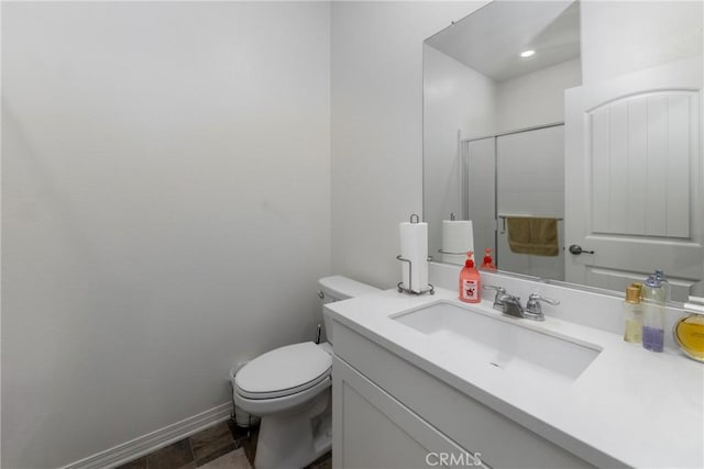 bathroom featuring toilet, vanity, and an enclosed shower