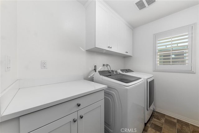 clothes washing area featuring cabinets and independent washer and dryer